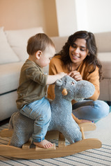 Wall Mural - baby playing with a rocking horse