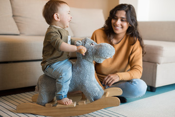 Wall Mural - baby playing with a rocking horse