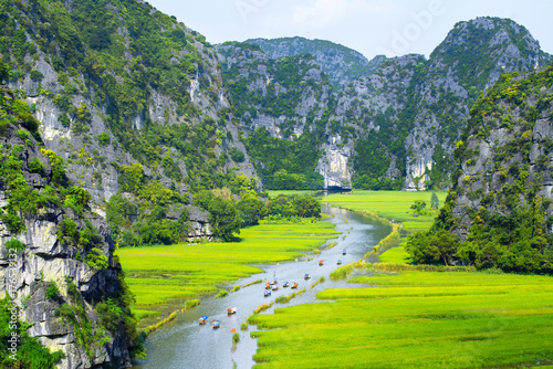 Foto Tourist ride boat for travel sight seeing Rice field on river "Ngo Dong" at TamC