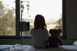 © EstudiM6/Stocksy - Silhouette of child patient and teddy bear looking through the hospital window