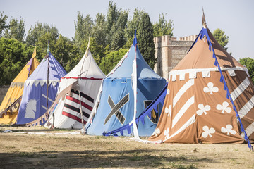 medieval tents next to a field of fair or mourning between warriors