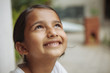© Shikhar Bhattarai/Stocksy - A young south asian girl smiling and looking up.