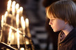 Portrait of a child standing by the burning candles at St. Paul's Cathedral in London, UK