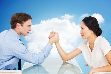 Poster - Composite image of business couple arm wrestling at desk