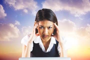 Poster - Composite image of nervous businesswoman using a laptop