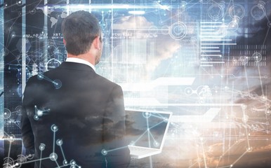 Poster - composite image of businessman looking up holding laptop