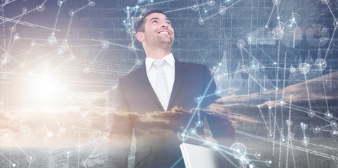 Poster - composite image of businessman looking up holding laptop