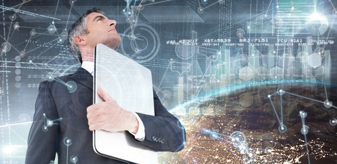 Poster - Composite image of businessman in suit holding his laptop