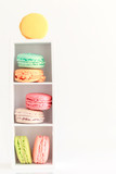 Fototapeta Storczyk - Colorful French macaroons on small wooden stand on white background