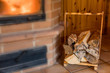 Firewood in wooden rack near the fireplace, fireplace is blurred for copy space