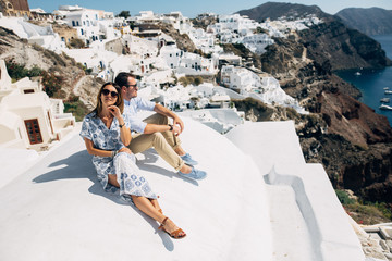 Wall Mural - The couple is sitting on the roof in Santorini, hugging and laughing