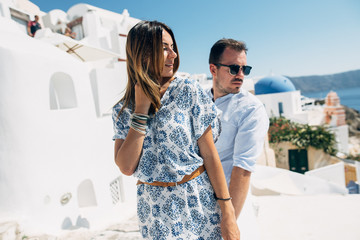 Happy couple hugging and laughing together with a view of Santorini