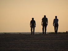 Three Men Walking On Beach