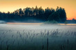  Sunset in countryside at mid summer. Hay rolls and road in misty weather with clear sunny sky. Beautiful nature in Latvia in August. 