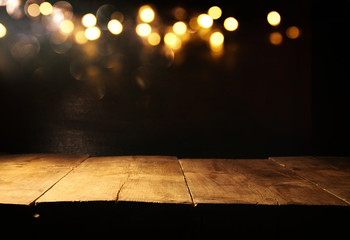 Empty table in front of black and gold glitter lights background