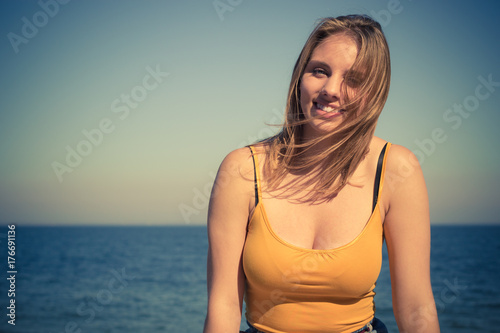 Plakat Urocza blondynki dziewczyna relaksuje plenerowy nadmorski