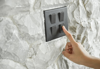 Wall Mural - lighting switch on rough stone wall.