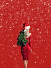 Girl In A Red Dress On A Red Background In A Santa Hat With A Backpack Out Of Which The Branches Of A New Year Tree Stick Out