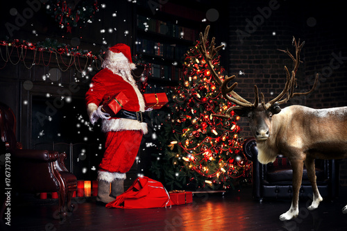 Plakat Świąteczna noc, Święty Mikołaj stawia prezenty pod drzewem