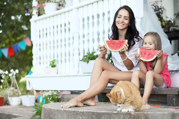 A young girl in a country house in nature eating a watermelon