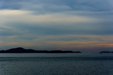 Wall Mural - beautiful panorama landscape of sea at dusk in evening when sunset with multicolor light with mountain, blue sky and cloud  background. sky and sea twilight.