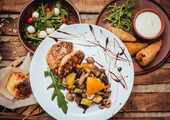 Wall Mural - Tasty meat rolls with sour cream and salad on wooden table