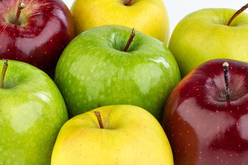 Ripe red, yellow and green apples on white background