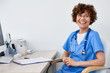© Seventyfour - Portrait of friendly female doctor sitting at desk in office  and laughing happily, copy space