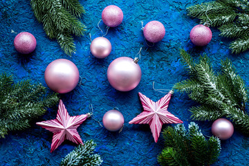 New year decoration. Christmas balls and stars with spruce branches on blue background top view pattern