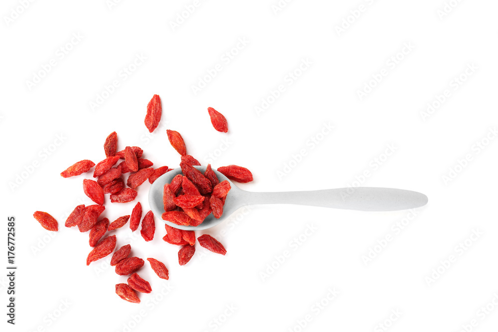 Spoon with red dried goji berries on white background