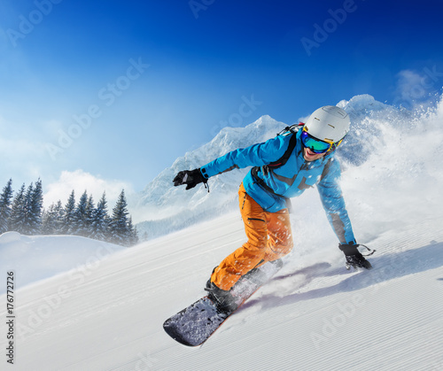 Obrazy Sporty Zimowe  mlody-czlowiek-snowboardzista-zjezdzajacy-po-zboczu-w-alpejskich-gorach