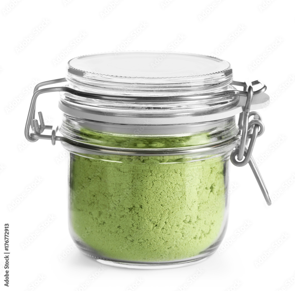 Glass jar with wheat grass powder on white background