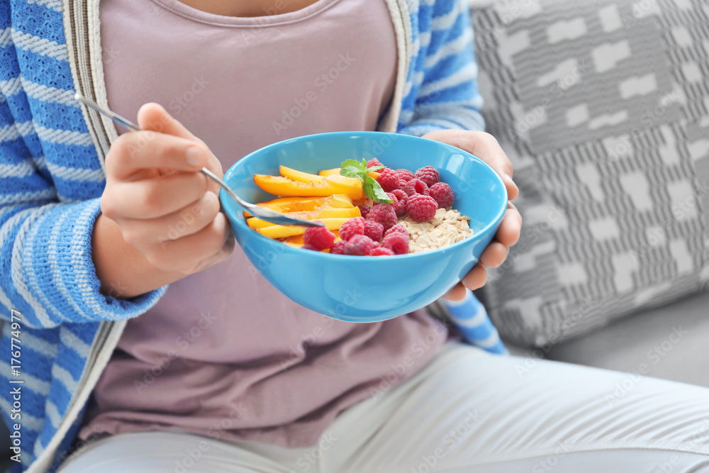 Woman eating oatmeal indoors