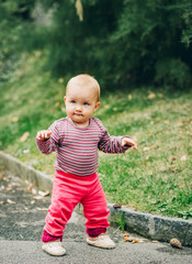 Adorable baby girl of 9-12 months old playing outside