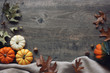 © IrisImages - Thanksgiving season still life with colorful small pumpkins, acorn squash, soft blanket and fall leaves over rustic wooden background