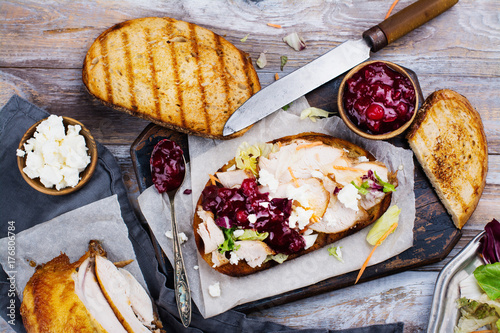 Fotomural Homemade leftover thanksgiving day sandwich with turkey, cranberry sauce, feta cheese and vegetables