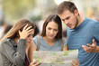 © Antonioguillem - Three lost tourists trying to find a location in a map