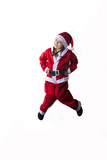 Fototapeta Sport - Little caucasian girl dressed as Santa Claus jumping on white background.