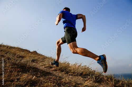 Cuadros en Lienzo dynamic running uphill on trail male athlete runner side view