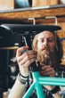 © Julien L. Balmer/Stocksy - Bearded Bicycle Mechanic Using Screwdriver