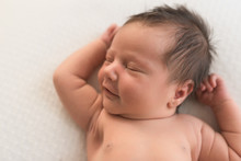 A Newborn Baby Smiles While Sleeping