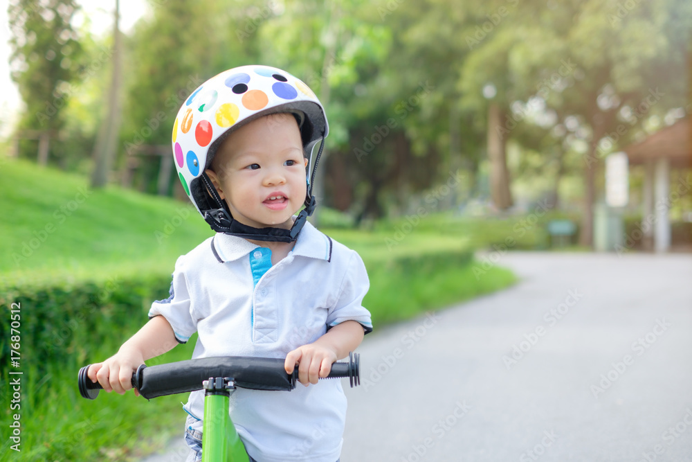 baby wearing bike helmet Photo Stock Cute little Asian 1 years / 18 months old baby boy child wearing  safety helmet learning to ride first balance bike in sunny summer day, kid  playing & cycling at