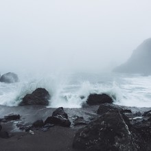 Ocean Waves Hitting Rocks On Beach In Jenner California On Foggy Day