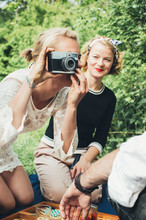 Two Blond Women Having Fun With Old Film Camera On Sunny Day In Nature