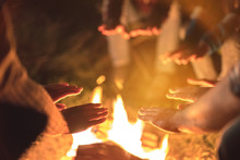 The People Warming Hands Near A Bonfire. Evening Night Time