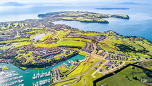 Aerial View On Residential Suburbs Surrounded By Sunny Ocean Harbour. Whangaparoa Peninsula, Auckland, New Zealand