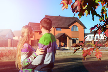 Wall Mural - Rear view of young couple looking at their new house