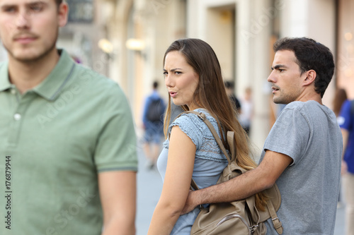 Photographie Disloyal woman looking another man and her angry boyfriend