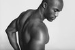 © Jacob Lund/Stocksy - Young african man with muscular build looking down