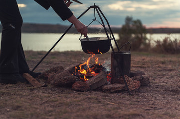 Preparing food on campfire in wild camping, resting on the nature